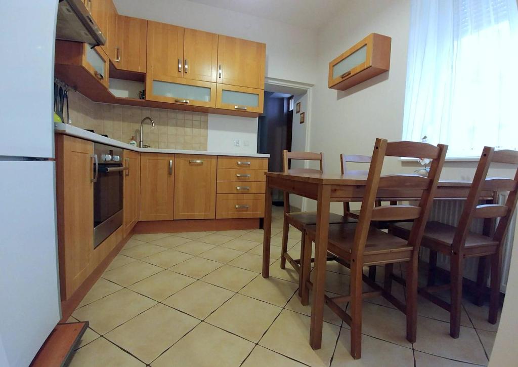 a kitchen with a wooden table and chairs and a kitchen with a sink at Apartament Oficyna in Krakow