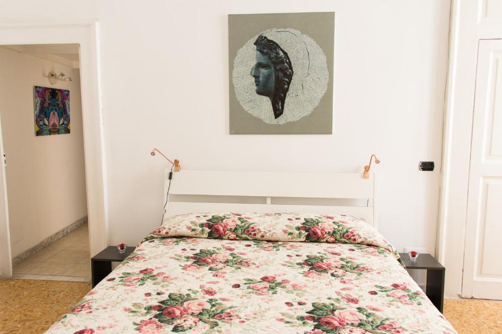 ナポリにあるB&B Cirillo 65のベッドルーム1室(花柄のベッドカバー付)