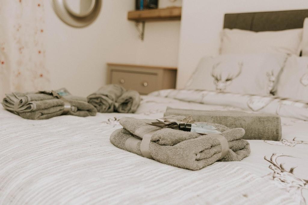 un grupo de toallas sentadas encima de una cama en The King Street Holiday Apartment in Inverness City Centre, en Inverness