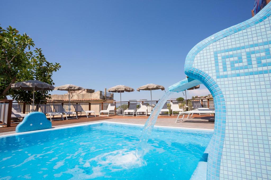 a swimming pool with a water fountain in a resort at IL SOFFIO DI TIFEO - RESORT in Ischia