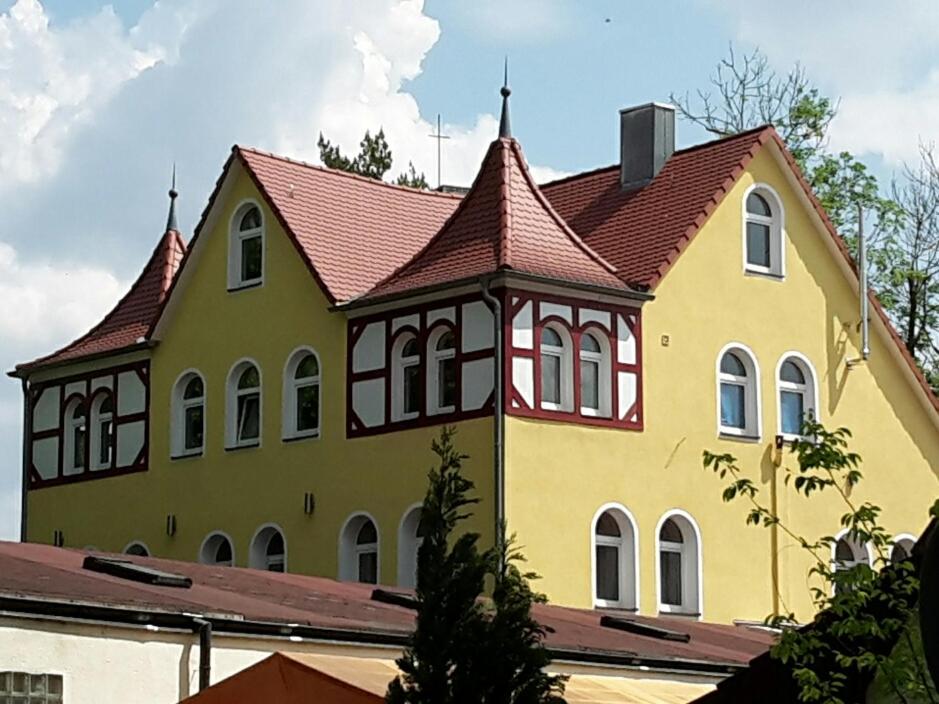 een groot geel huis met een rood dak bij Wunderschöne Wohnungen im Zentrum von Herzogenaurach in Herzogenaurach