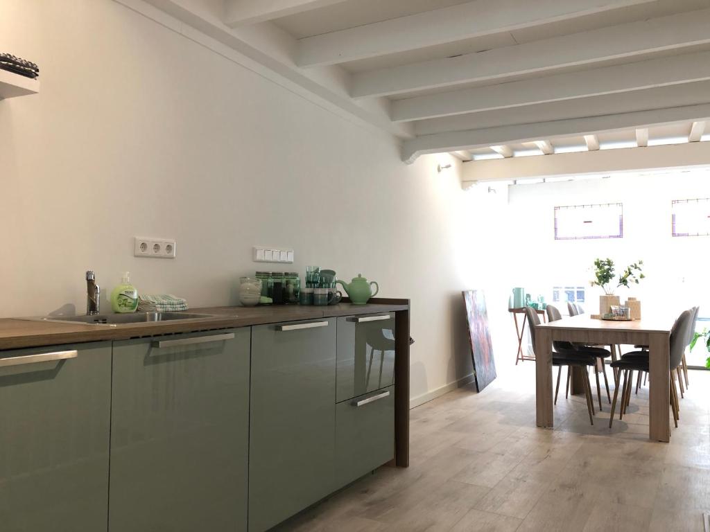 uma cozinha com uma mesa de madeira e uma sala de jantar em No6a Luxe design appartement in historisch hart Dordrecht ALLES dichtbij! em Dordrecht