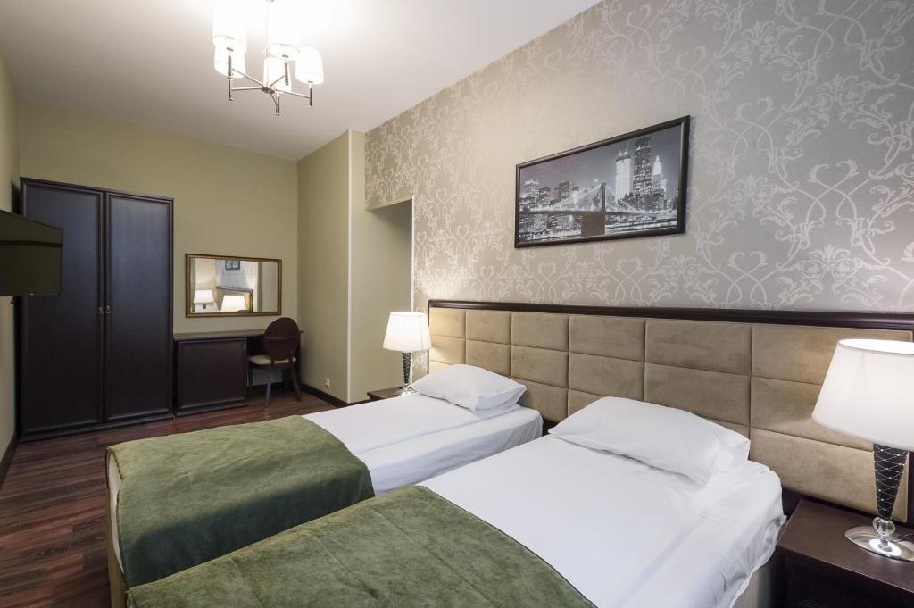 ジュコーフスキーにあるHotel Druzhbaのベッド2台と鏡が備わるホテルルームです。