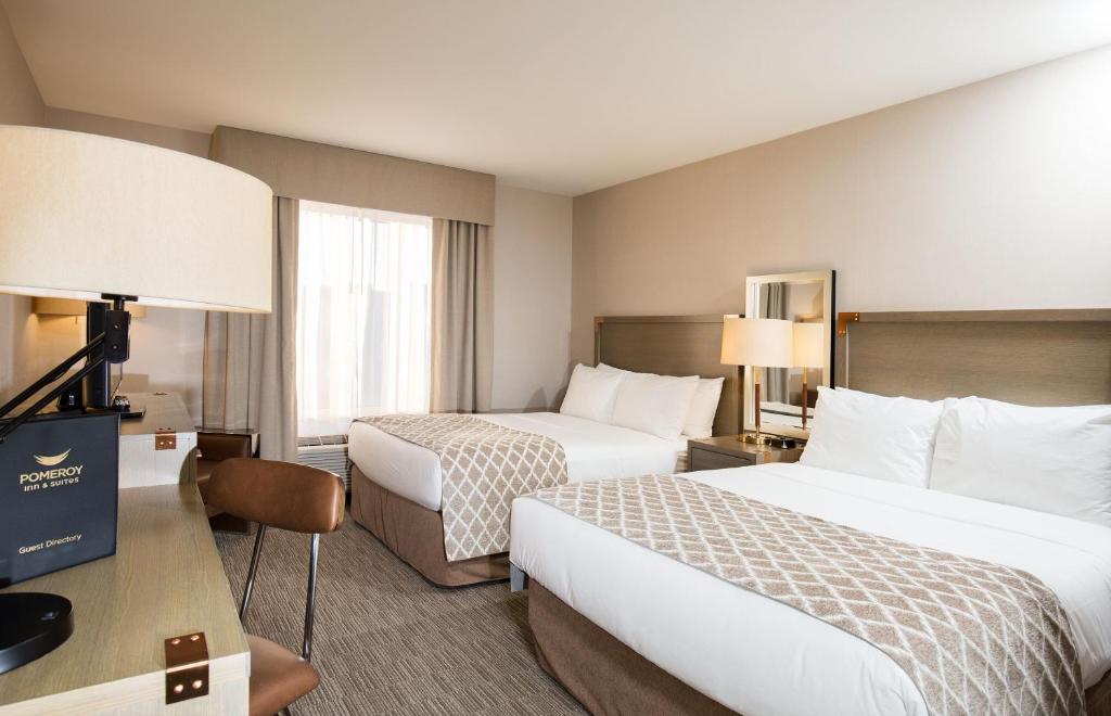 Postel nebo postele na pokoji v ubytování Pomeroy Inn & Suites Prince George