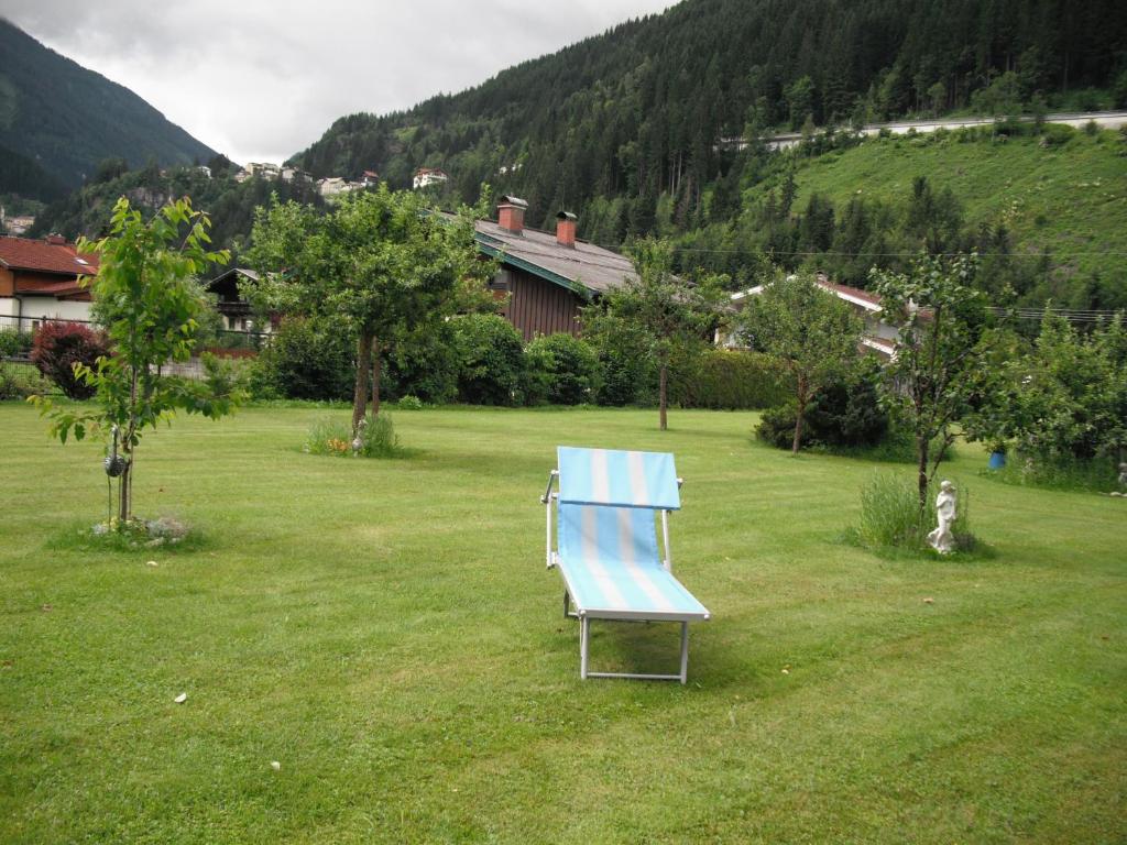 une chaise bleue assise dans l'herbe dans une cour dans l'établissement Haus Christophorus, à Bad Gastein