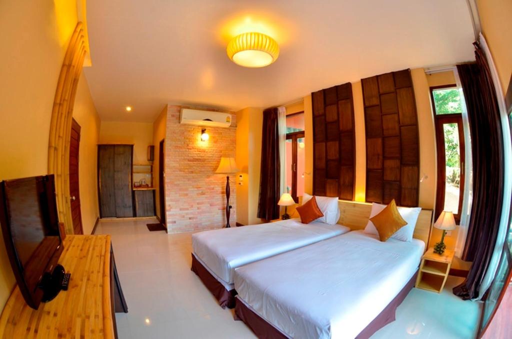 a bedroom with a large bed and a table at Palm Leaf Resort Koh Tao in Ko Tao