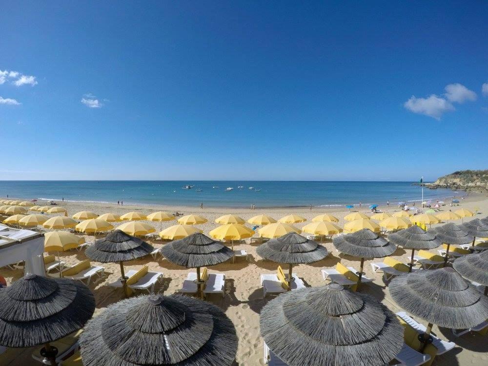 a group of umbrellas on a beach with the ocean at Apartamentos Borda D´Agua in Albufeira