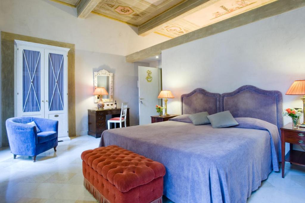 a bedroom with a bed and a chair and a table at Alloro B&B in Florence