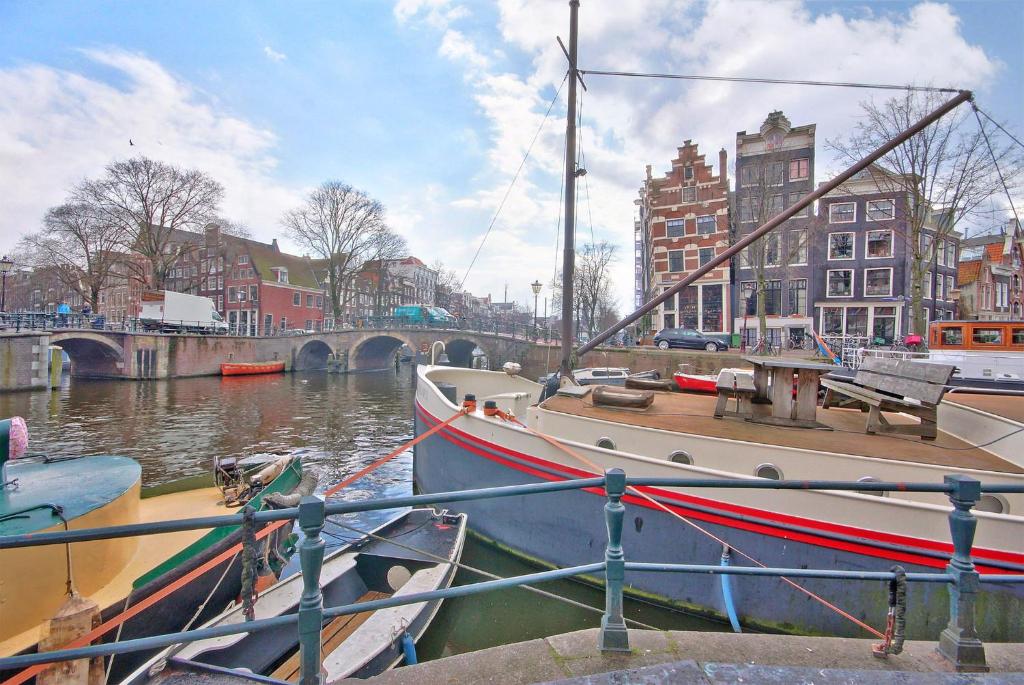 a boat is docked at a dock in a canal at Houseboat Prince William & Houseboat Prince Arthur in Amsterdam