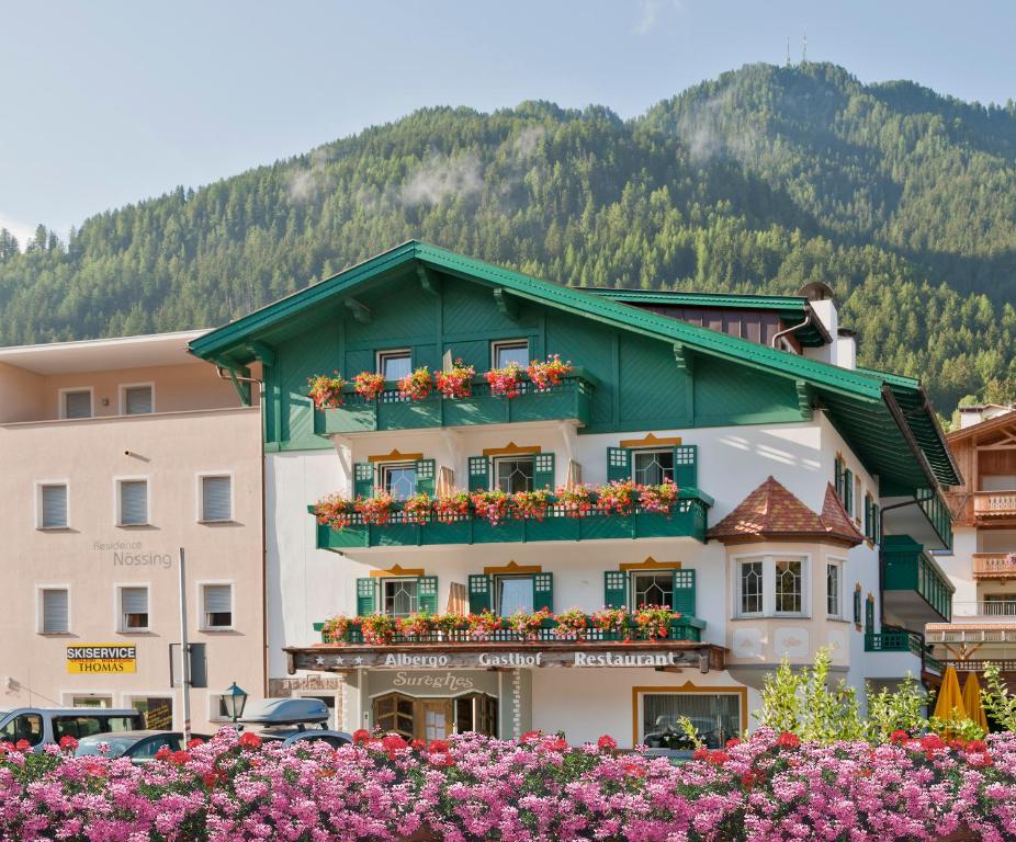 ein Gebäude mit Blumen davor in der Unterkunft Hotel Sureghes in St. Ulrich in Gröden