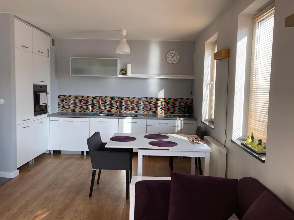 eine Küche mit einem Tisch und einem Sofa in einem Zimmer in der Unterkunft Apartamenty Tychy Bielska 149A in Tychy