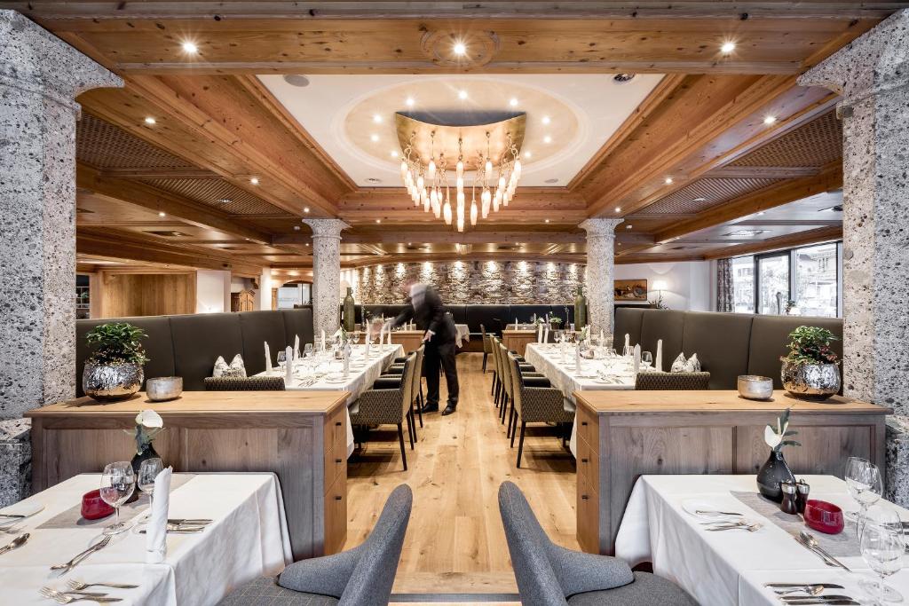 Elegantes Restaurant im Das Central Sölden mit festlich gedeckten Tischen, Kronleuchtern und gemütlicher Atmosphäre
