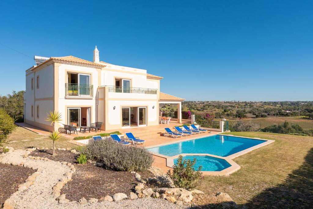 a villa with a swimming pool in front of a house at Villa Agua by Gabi Miguel in Albufeira