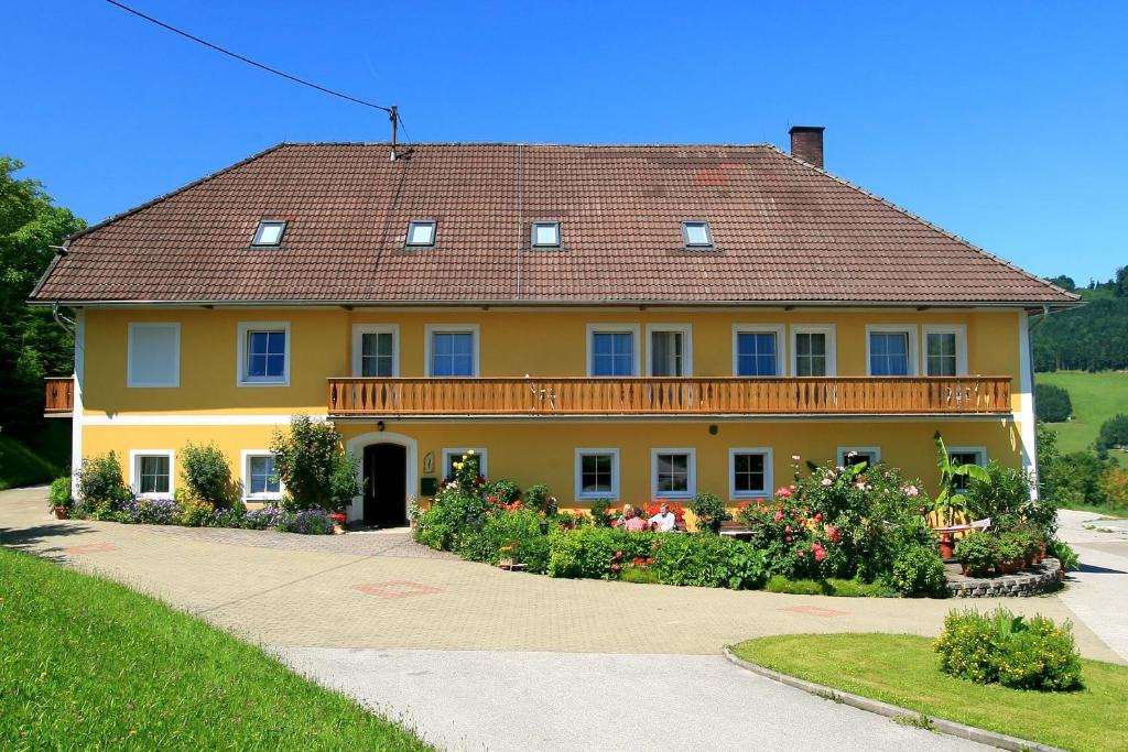 ein großes gelbes Haus mit braunem Dach in der Unterkunft Ferienhof am Landsberg in Obergrünburg