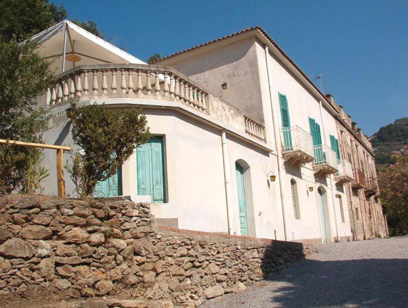 ein großes weißes Haus mit einer Steinmauer in der Unterkunft Villa Caferì in San Giorgio