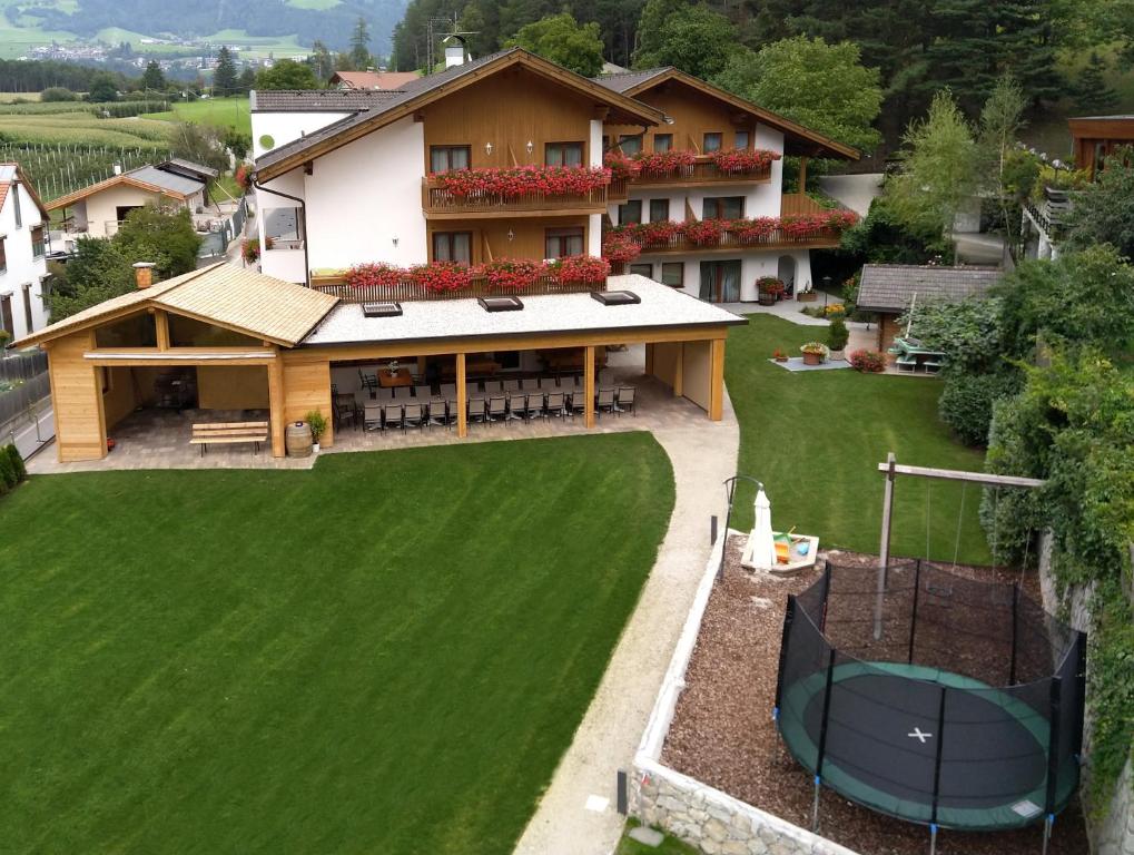 une vue aérienne sur une maison avec une pelouse verte dans l'établissement Hotel Föhrenhof, à Naz-Sciaves