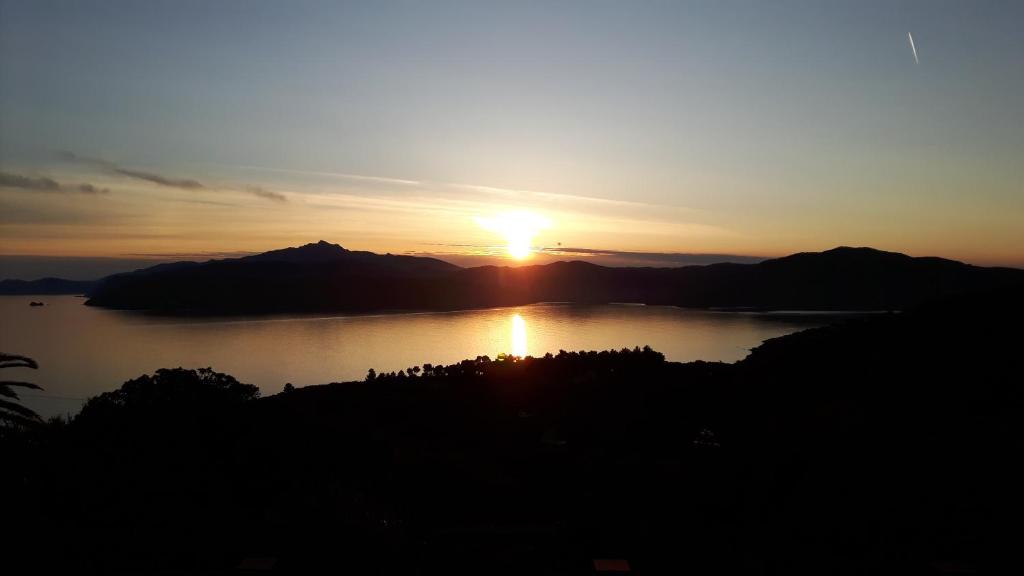 a sunset over a body of water with mountains at Appartamenti Il Sogno in Capoliveri
