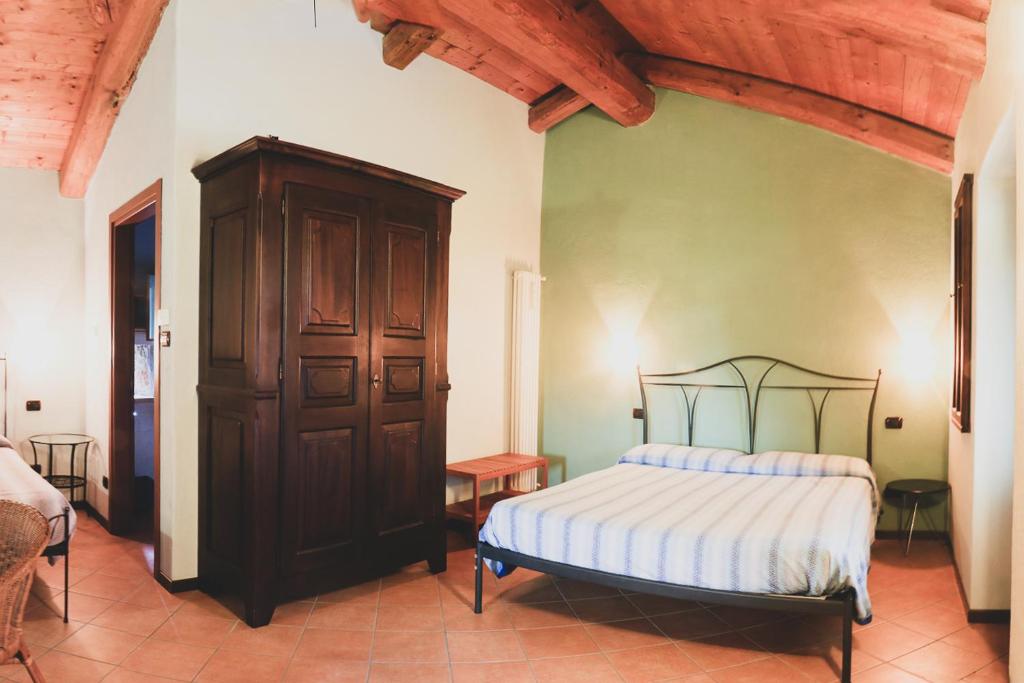 1 dormitorio con 1 cama y armario de madera en Agriturismo Fiori di Zucca, en Fossano
