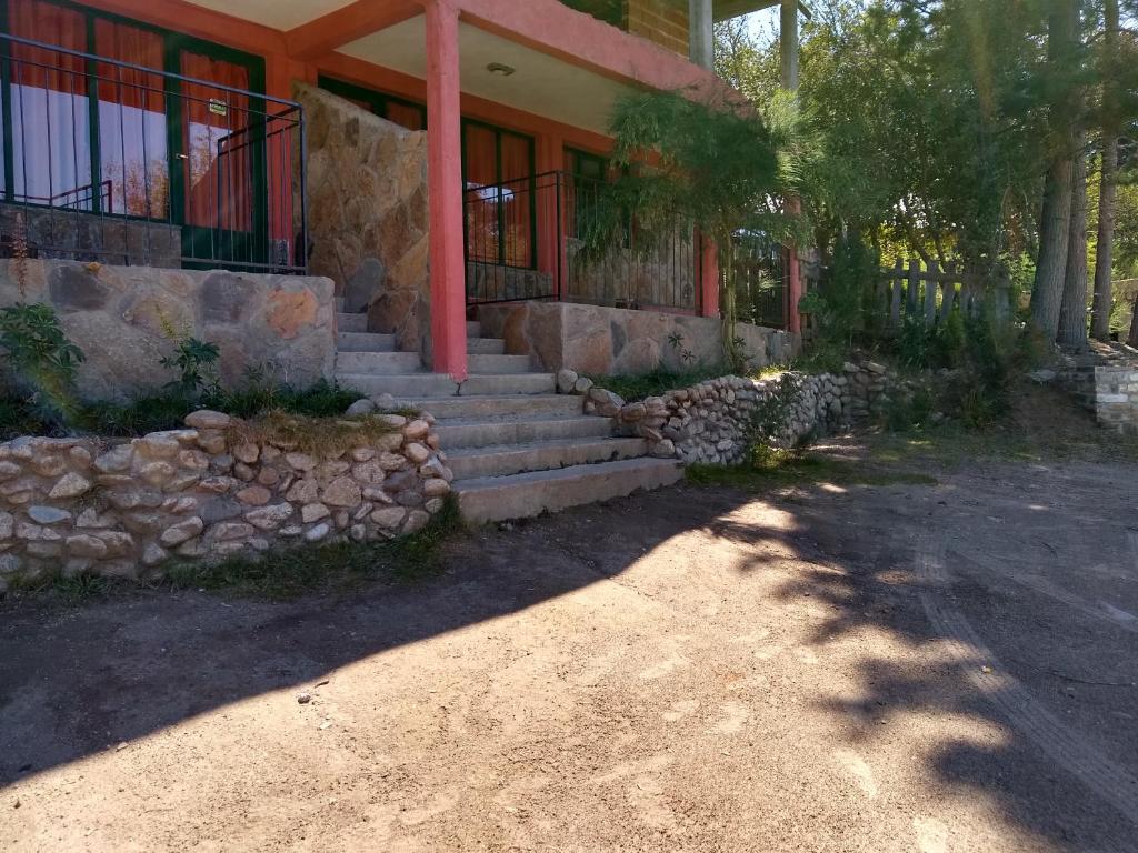 una casa con una escalera de piedra delante de ella en Laguna Verde Departamentos en Villa Pehuenia