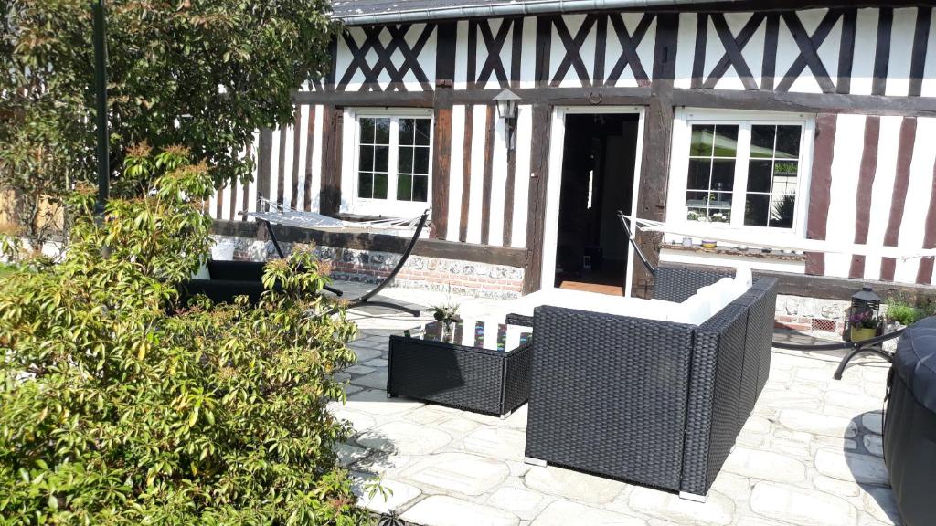a patio with a black and white building with chairs at CAMPAGNE ET MER in Saâne-Saint-Just
