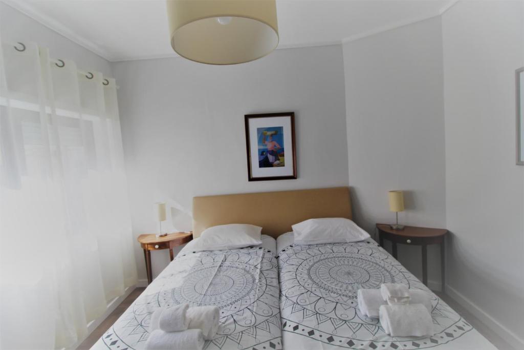- une chambre avec un lit et 2 oreillers blancs dans l'établissement Apartamento com Patio, à Aveiro