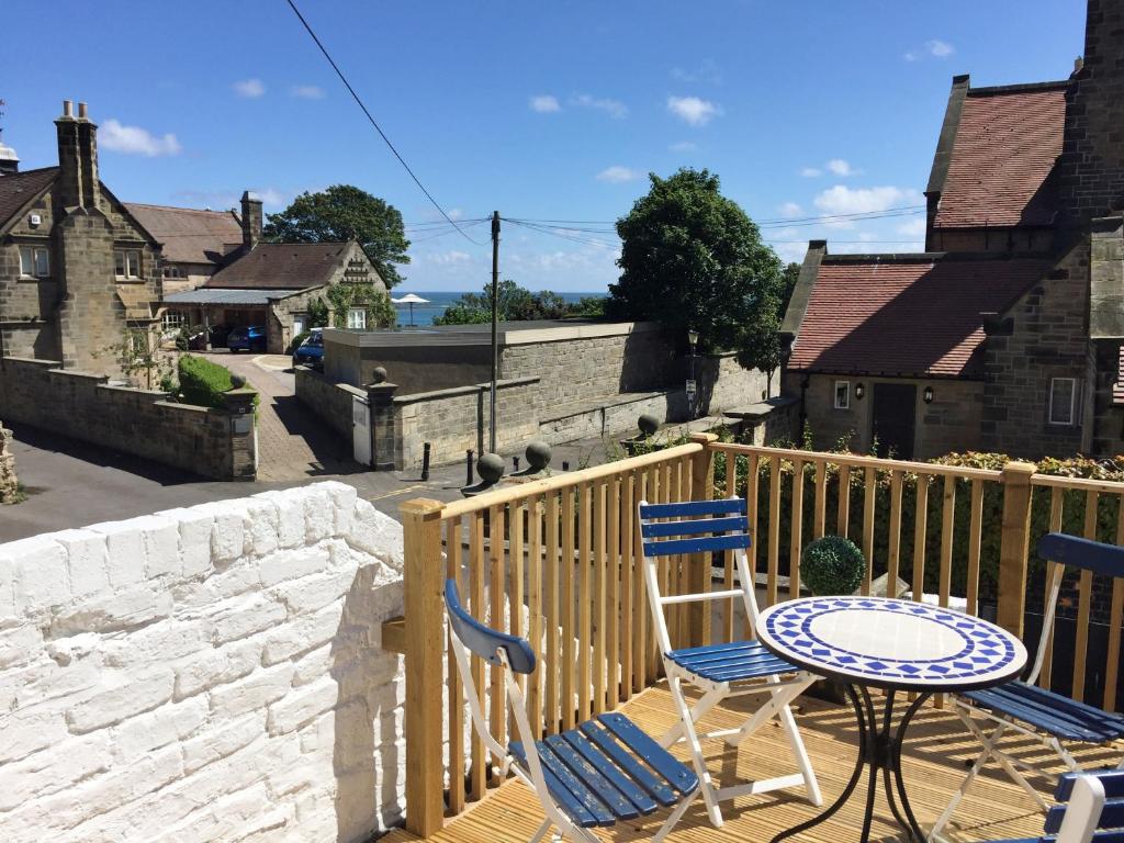 a patio with two chairs and a table on a balcony at Heart of Filey in Filey
