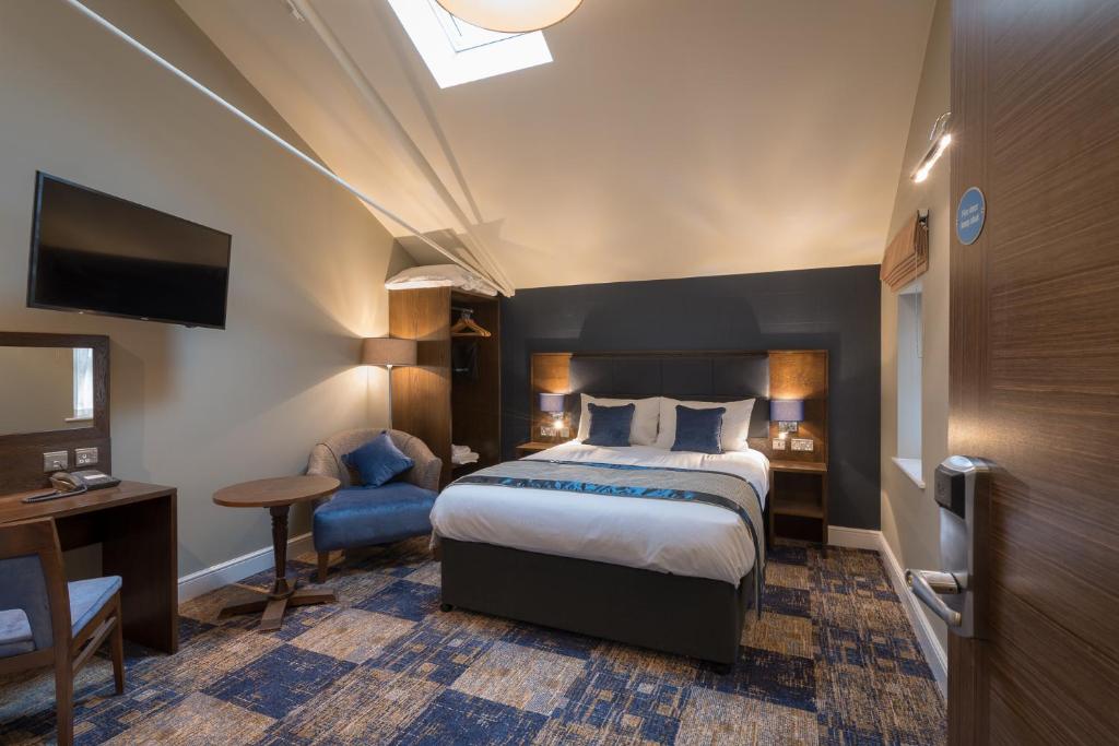 um quarto de hotel com uma cama e uma cadeira em The John Russell Fox Wetherspoon em Andover