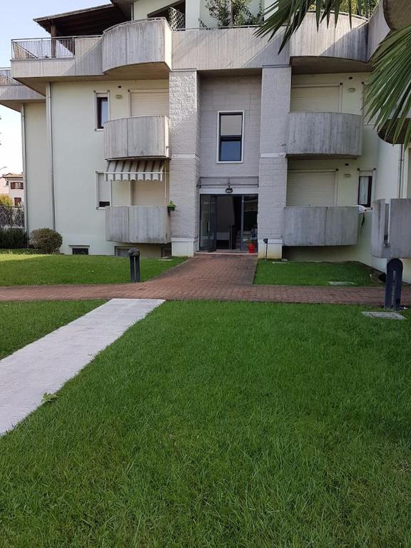 a large white building with a green lawn in front of it at Residenza Annalisa in Torri di Quartesolo