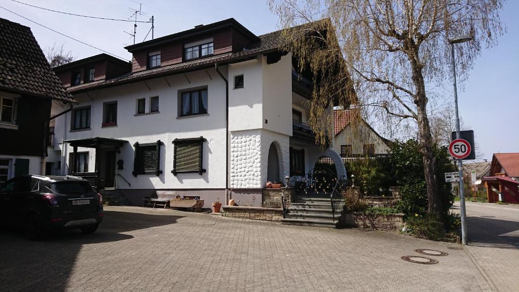 una casa bianca con una macchina parcheggiata di fronte di Pension Schlossbergblick a Simonswald