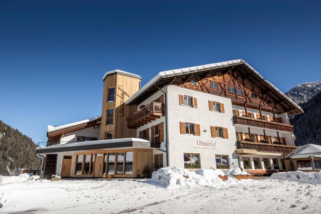 a large building with snow in front of it at Hotel Ultnerhof in Santa Gertrude nella Val d'Ultimo