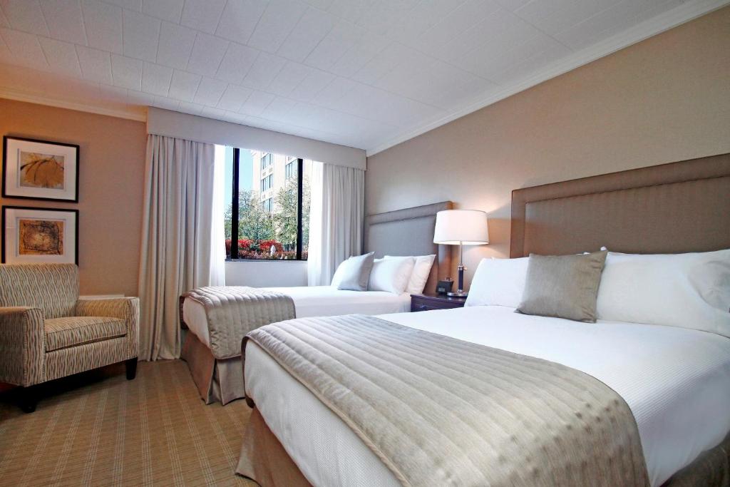 Ethan Allen Hotel في دانبري: غرفة فندقية بسريرين وكرسي
