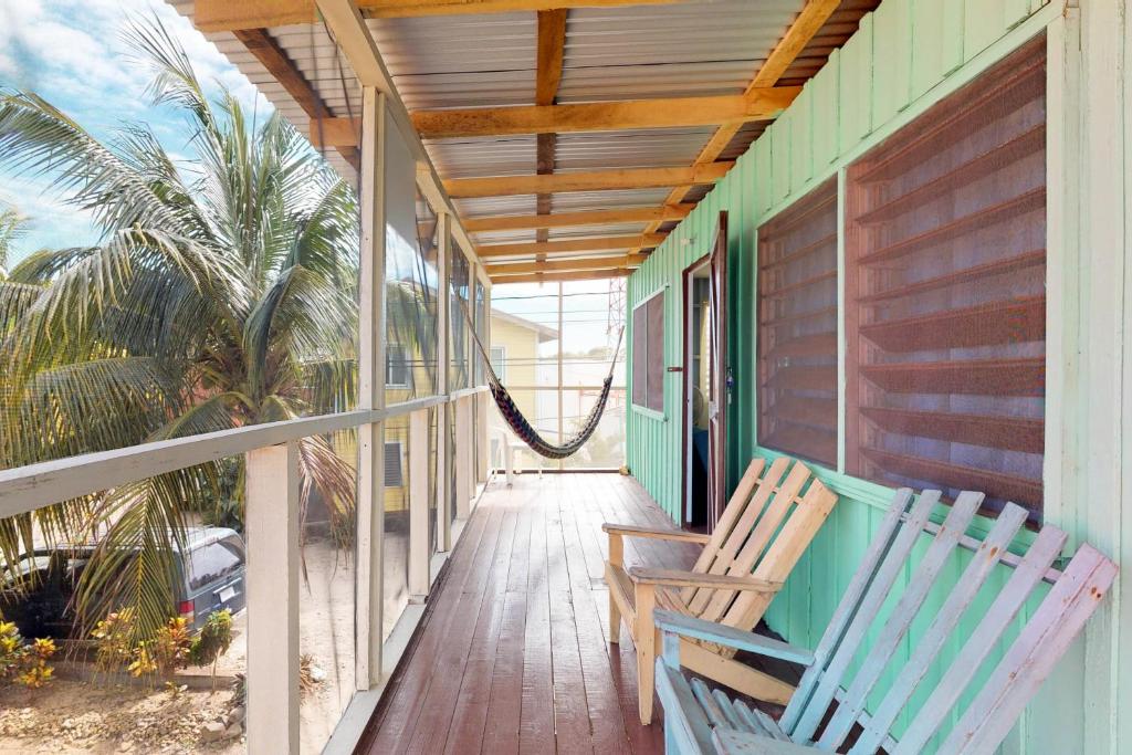 2 Stühle auf der Veranda eines Hauses in der Unterkunft Carol's Cabanas in Placencia Village