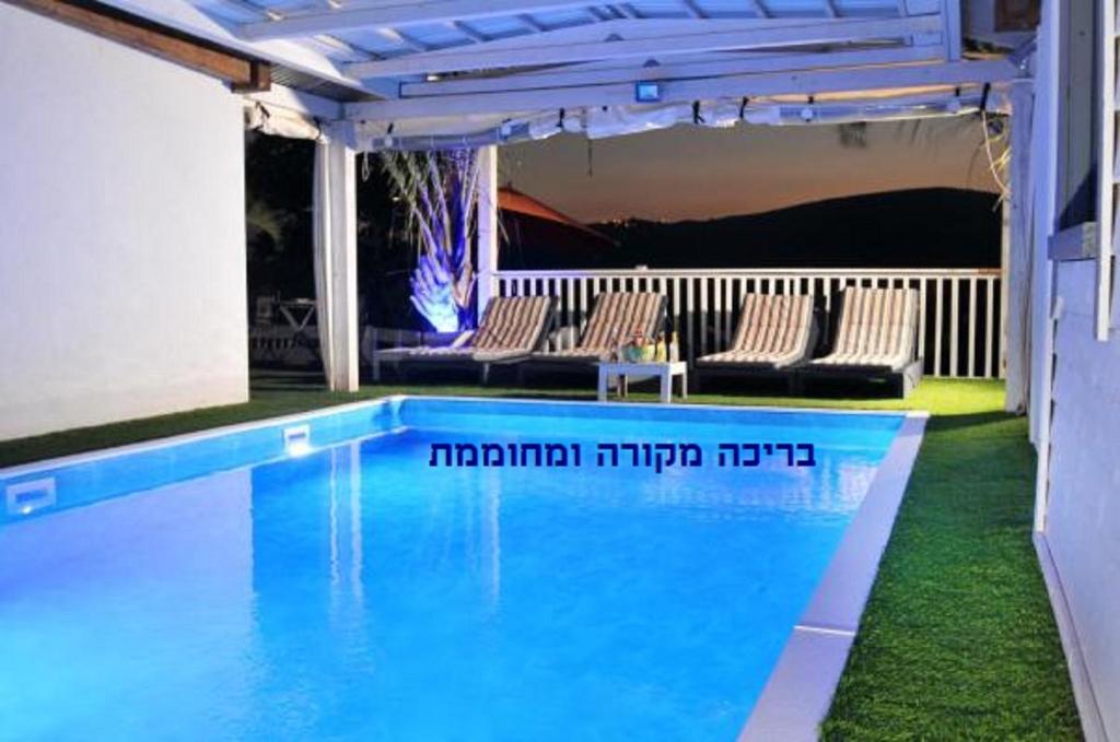 una piscina con sillas en un patio con en Kesem Ba Golan, en Had Nes