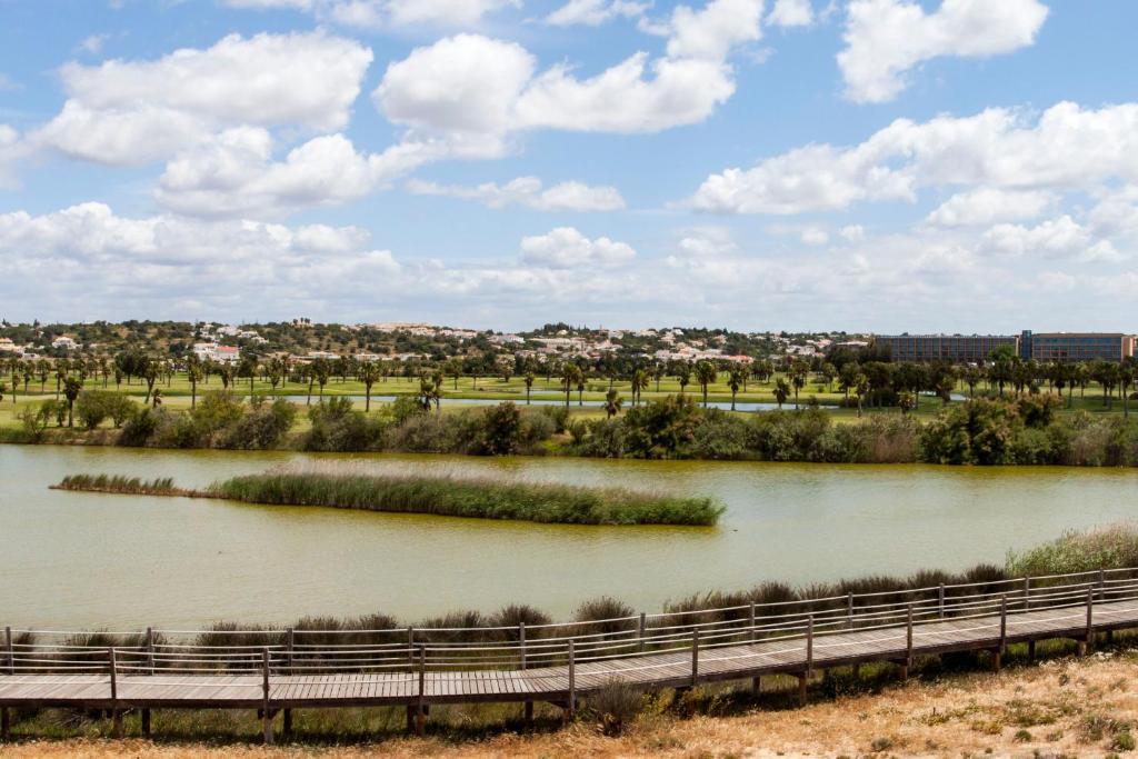 a river with a bridge and a city in the background at Bayside Salgados in Albufeira
