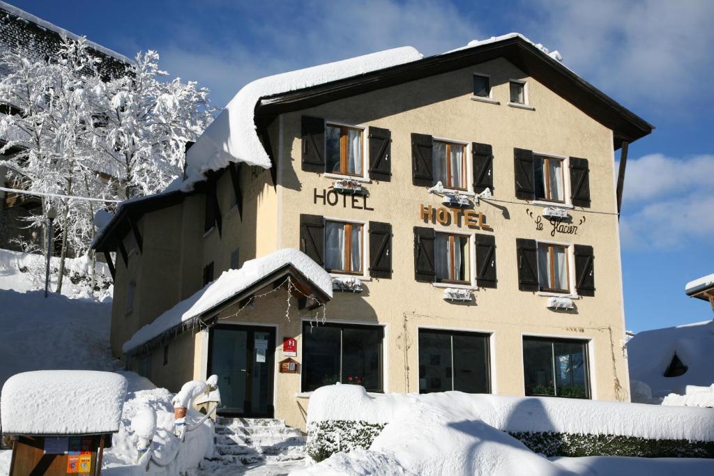 um hotel está coberto de neve na frente em Hôtel Le Glacier em Gourette