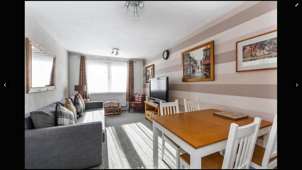 Lovely One Bedroom Apartment in Stratford في لندن: غرفة معيشة مع أريكة وطاولة طعام