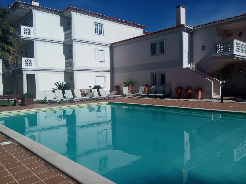 a swimming pool in front of a building at Praia Del Rey ViewPool Sea in Amoreira