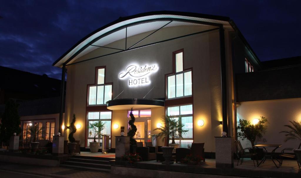a restaurant with a lit up sign on the front of it at Hotel Residenz Babenhausen - Superior in Babenhausen