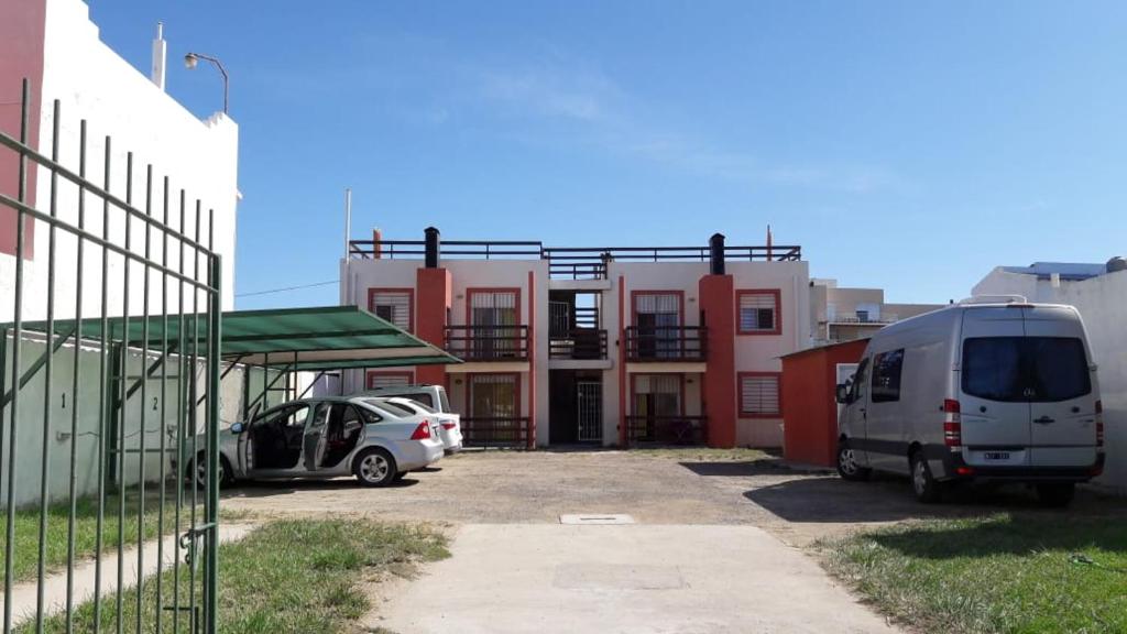 una furgoneta estacionada en un estacionamiento al lado de un edificio en Complejo Evelin en Las Grutas