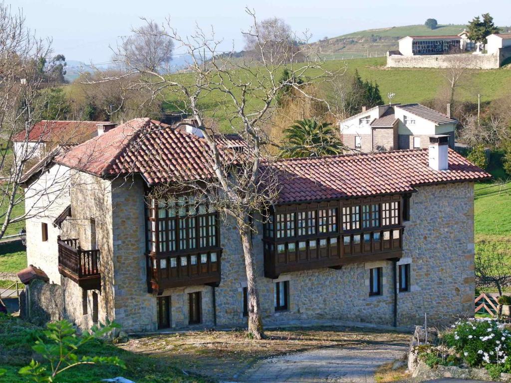 una gran casa de piedra con techo rojo en La Posada de Abanillas, en Abanillas