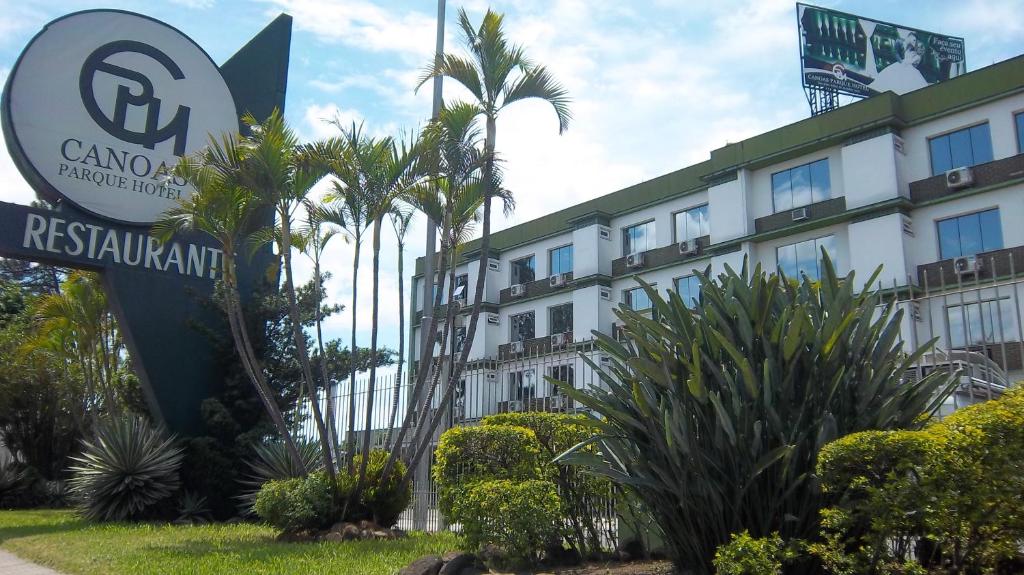 um hotel com uma placa em frente a um edifício em Canoas Parque Hotel em Canoas