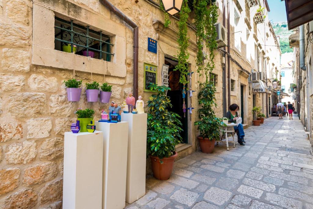 a street in an old town with potted plants at Studio Sonnet in Dubrovnik