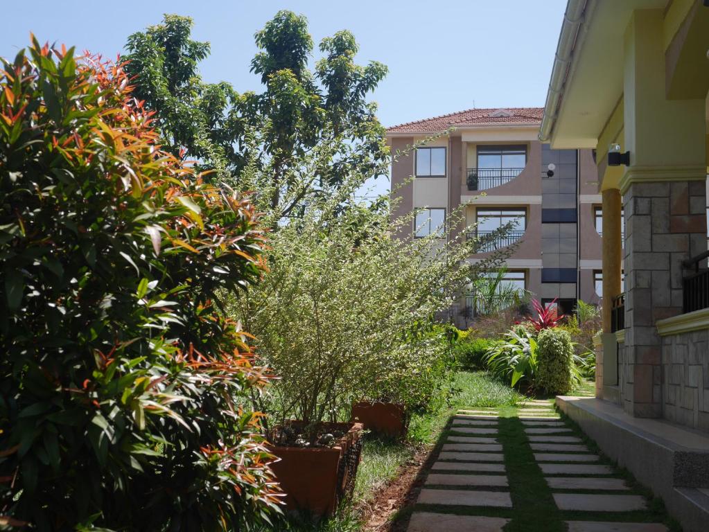 einen Garten mit einigen Pflanzen und einem Gebäude in der Unterkunft Ntinda View Apartments in Kampala