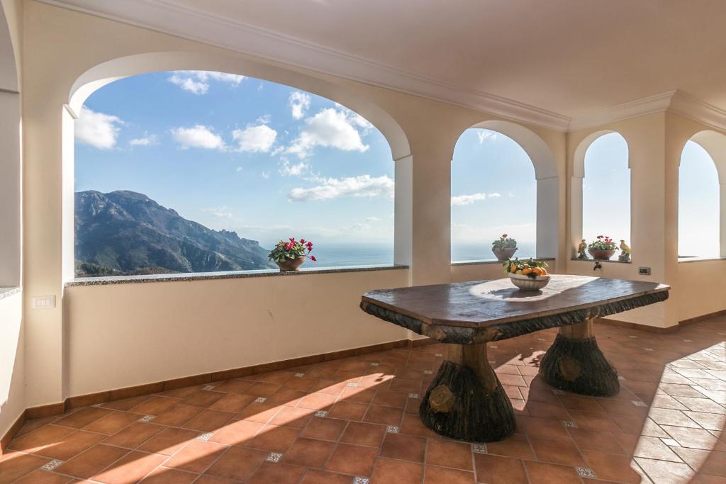 een grote kamer met een tafel en een groot raam bij La Luna di Cristina in Ravello