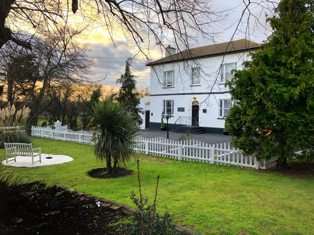 une maison blanche avec une clôture blanche dans l'établissement STIFFORD CLAYS FARM HOTEL, à North Stifford