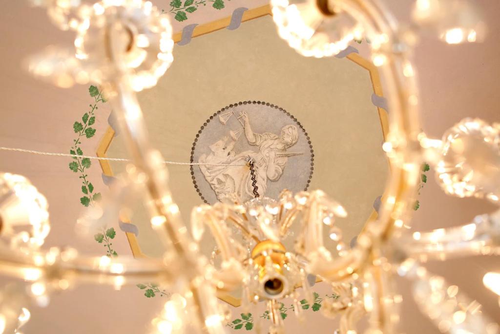 un primer plano de una lámpara de araña con una foto en Residenza D'Epoca -Santa Caterina, en Pisa