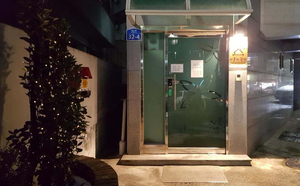 uma porta verde num edifício com um sinal em I sleep alone em Seul