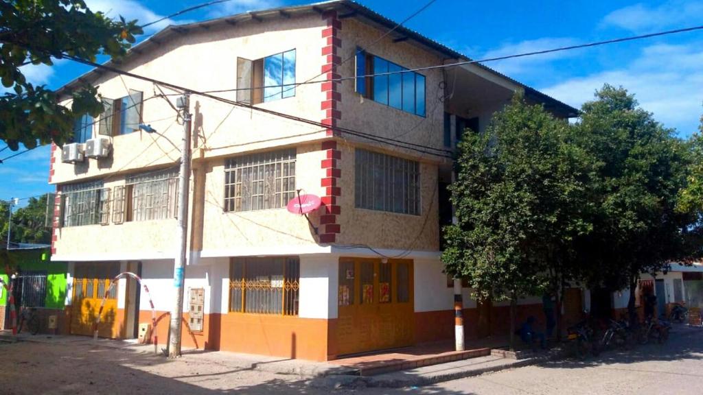 ein weißes und orangefarbenes Gebäude mit einem Baum davor in der Unterkunft Merkezi Saray in Villavieja