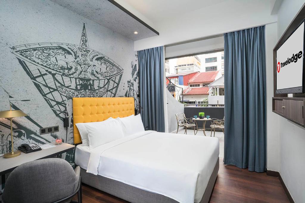 Cette chambre comprend un lit, un bureau et une fenêtre. dans l'établissement Travelodge Chinatown Kuala Lumpur, à Kuala Lumpur