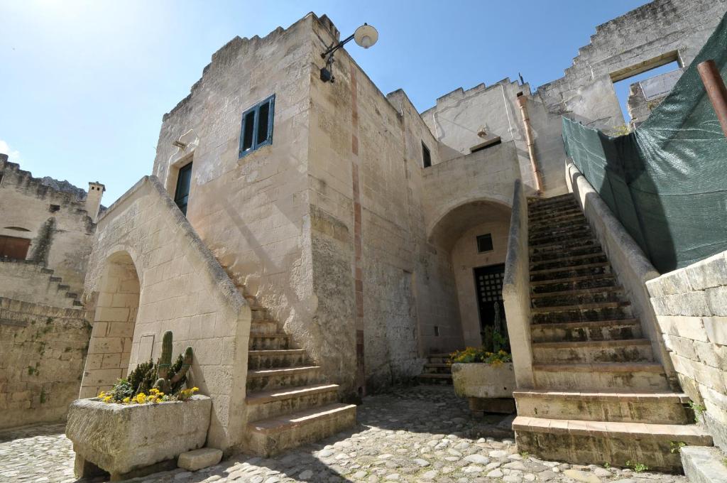 ein altes Steingebäude mit einer Treppe im Innenhof in der Unterkunft Agli Archi Dimore Storiche in Matera